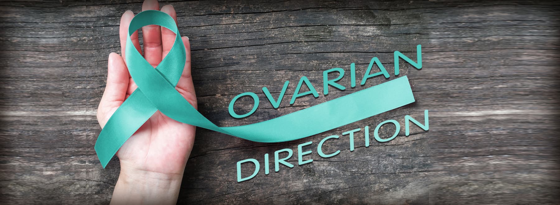 Hand holding ovarian cancer turquoise ribbon